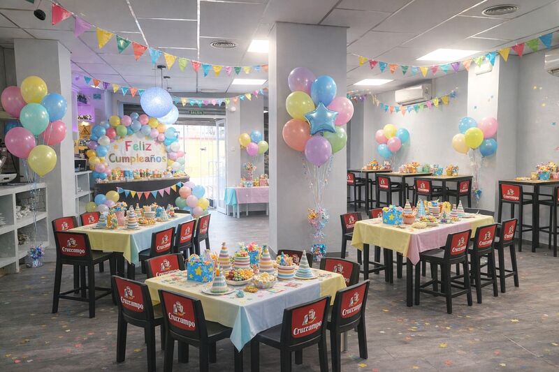Fiesta con mesas decoradas y globos pastel